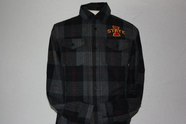 A black and grey plaid shirt with an orange cross on the front.